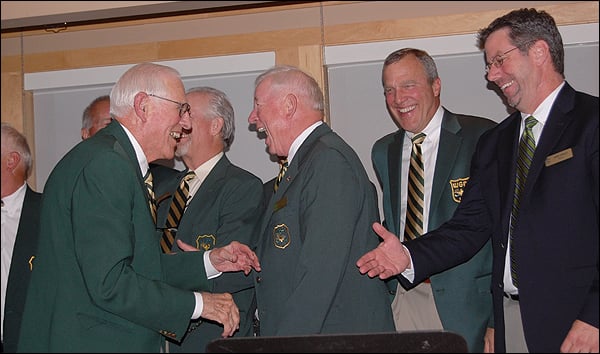 George Holland (left) is greeted on the stage at Caddie Hall of Fame induction