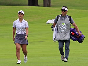 Brittany Kwon strolls down the fairway with her caddie in tow.