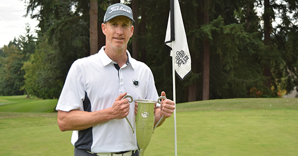 Erik Hanson poses with the Men's Mid-Amateur perpetual trophy.