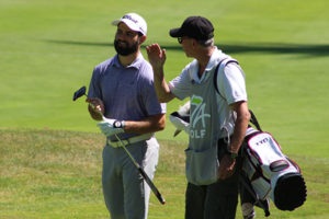 A player and his caddie stroll down the 18th fairway during today's qualifier.
